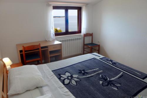 een slaapkamer met een bed, een bureau en een raam bij Apartmaji ORKO s pogledom na morje - Sea View Apartments ORKO in Portorož