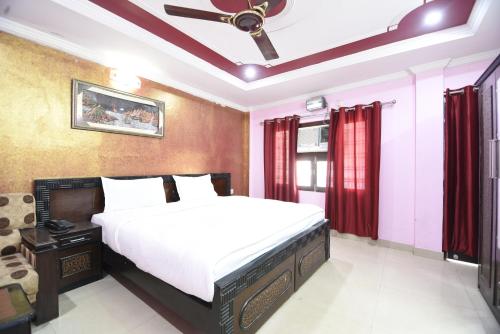 a bedroom with a bed and a ceiling fan at Hotel Aryan in Lucknow