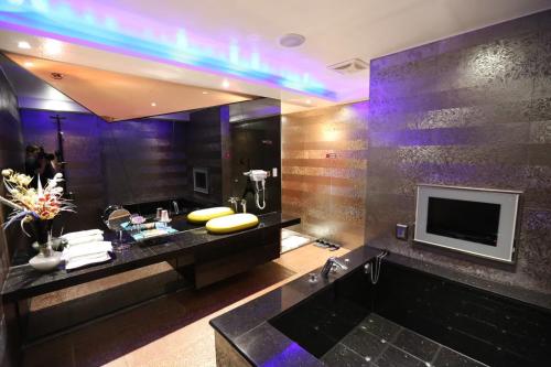 a bathroom with a tub and a tv on a wall at Yosemite Motel - Chunghua Branch in Taichung