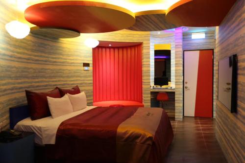 a bedroom with a large bed with a red curtain at Yosemite Motel - Chunghua Branch in Taichung
