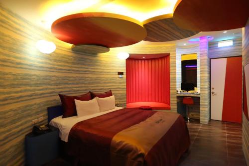 a bedroom with a large bed with a red curtain at Yosemite Motel - Chunghua Branch in Taichung