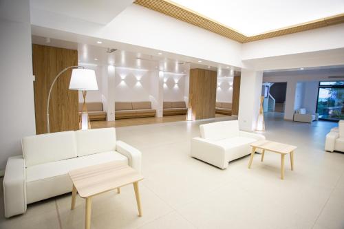 una sala de estar con 2 sofás blancos y una mesa. en Zenith - Top Country Line - Conference & Spa Hotel en Mamaia