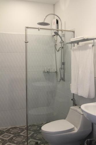 a bathroom with a shower with a toilet and a sink at ESC PARK HOTEL in Pathum Thani