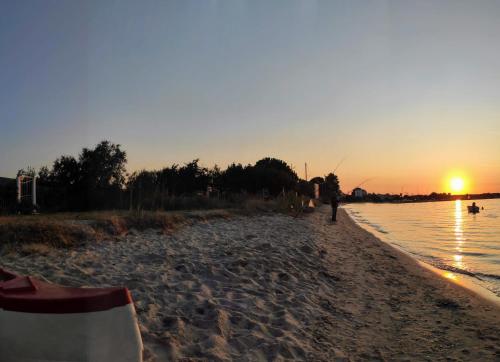 a person walking on the beach at sunset at Blue Breeze in Prinos