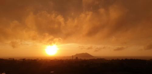 a sunset with the sun setting in the sky at Hi Jeju Hotel in Jeju