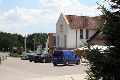 a blue van parked in a parking lot next to a building at Belvárdi Fogadó in Belvárdgyula