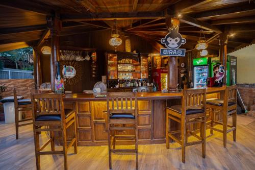 a bar with wooden furniture and chairs in a restaurant at Alcove Resort Vagator in Vagator