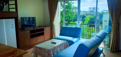 a living room with a couch and a chair and a window at The Icon Place 2 @ Nurn Plub Wan in Pattaya