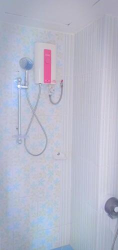 a bathroom with a shower with a pink box on the wall at The Icon Place 2 @ Nurn Plub Wan in Pattaya