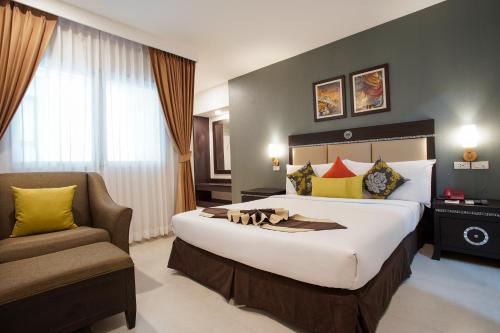 una habitación de hotel con una cama grande y una silla en Club Mahindra Mac Boutique Hotel en Bangkok