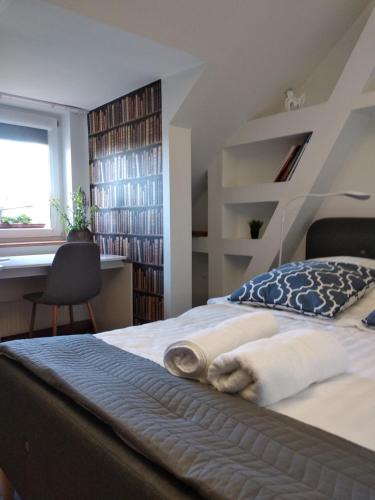 a bedroom with a bed and a desk and a window at Copernicus 10 in Olsztyn