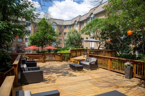 a wooden deck with chairs and tables in front of a building at Staybridge Suites Toronto - Vaughan South by IHG in Vaughan