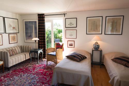 ein Wohnzimmer mit 2 Betten und einem Sofa in der Unterkunft Anne Just's Havehotel in Blokhus