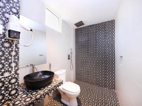 a bathroom with a sink and a toilet and a shower at Raintree Boutique Hotel in Kajang