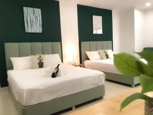 two beds in a room with green and white at KSL City Mall 4-6pax Netflix-SmartTV 65inch in Johor Bahru
