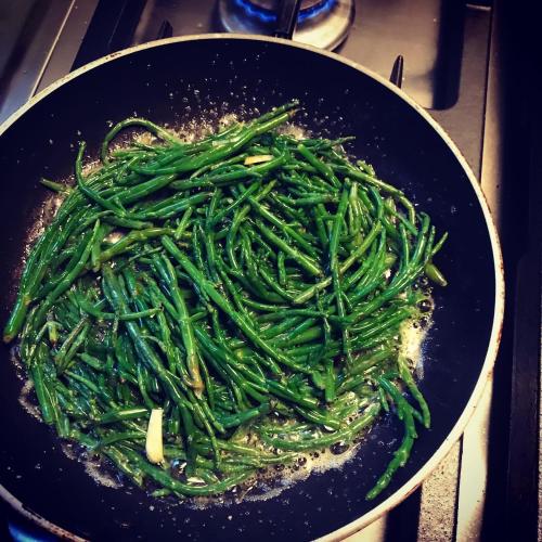 a pan filled with green beans sitting on a stove at La maison au fil du temps in Pont-Rémy