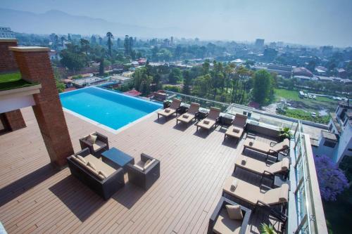 um deque com espreguiçadeiras e uma piscina num edifício em Hotel Mulberry em Kathmandu