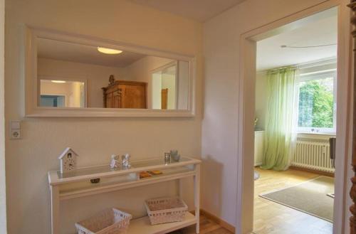 ein Badezimmer mit einem Spiegel und einem Regal mit Körben in der Unterkunft Ferienwohnung an der Elz in Emmendingen