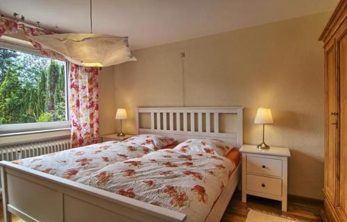 a bedroom with a bed and a window and two lamps at Ferienwohnung an der Elz in Emmendingen
