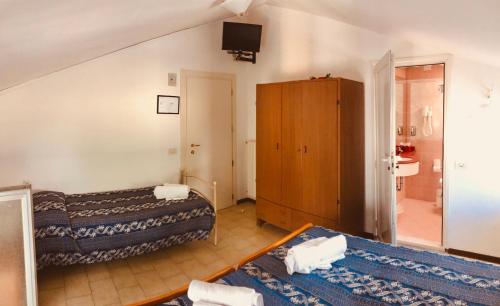 una camera d'albergo con due letti e un bagno di Hotel Villa Lieta a Rimini