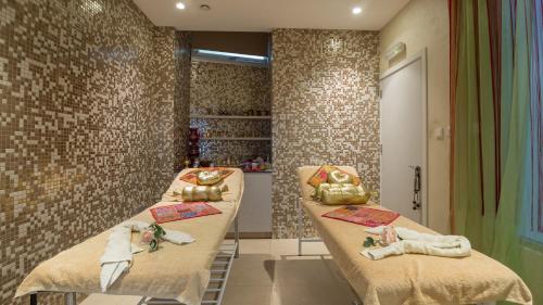 a room with three beds with towels on them at Vrissaki Beach Hotel in Protaras