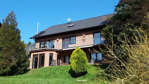 een groot bakstenen huis bovenop een heuvel bij Ferienwohnung Hammergrund in Mossautal