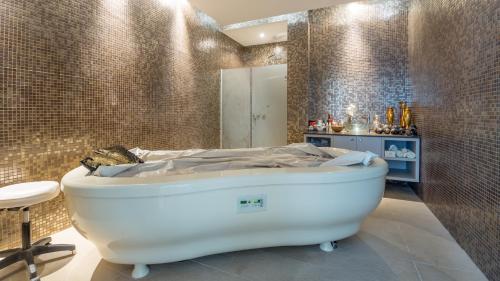 a bathroom with a white bath tub in a room at Vrissaki Beach Hotel in Protaras