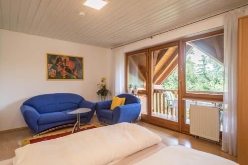 Il comprend un salon doté d'un mobilier bleu et d'un balcon. dans l'établissement Ferienwohnung Konrad Schielin, à Lindau
