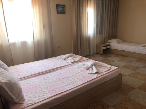 a bedroom with two beds with towels on them at Stoyko's Guest House in Pomorie