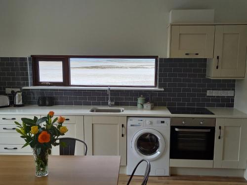 a kitchen with a washing machine and a window at Murrisk Apartments - Self Catering in Westport