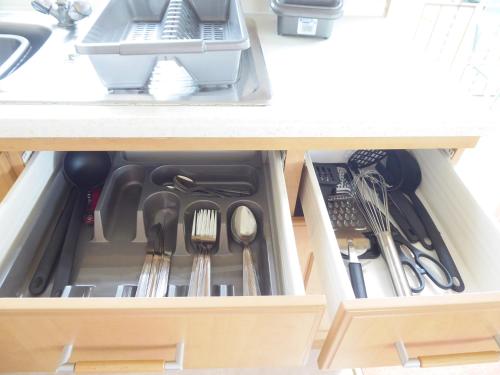a drawer in a kitchen cabinet with utensils at Beachside, Family-friendly, WiFi, 6 berth Caravan 226 in Ingoldmells
