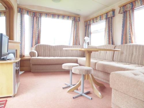 a living room with a couch and a table at Beachside, Family-friendly, WiFi, 6 berth Caravan 226 in Ingoldmells