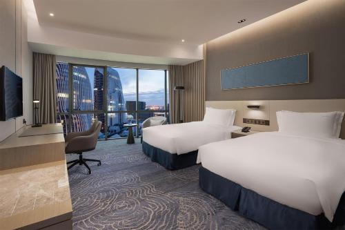a hotel room with two beds and a television at Holiday Inn - Nanjing South Station by IHG in Nanjing