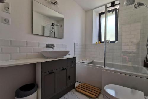 a bathroom with a sink and a tub and a toilet at Gite du Moulin Toucan in Berneuil