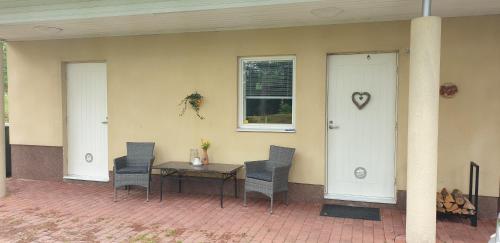 a patio with a table and chairs and a window at Villa Tammikallio Guest House, near the airport - Kodikas vierasmaja Tuusulassa in Tuusula
