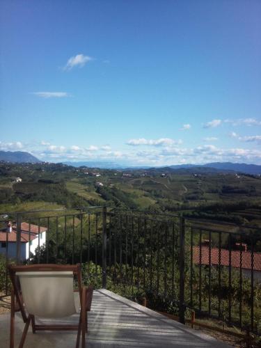 a chair on a balcony with a view of a valley at B&B Calligaris in Dobrovo