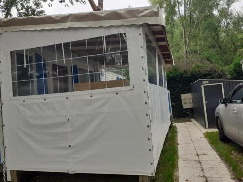 a white garage with a car parked in front of it at Mobilhome in Les Mathes