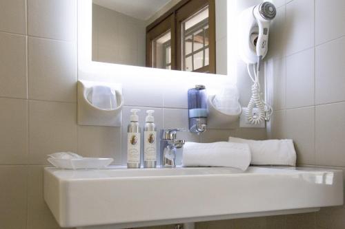 a bathroom sink with a hair dryer and a mirror at Albergo Al Cacciatore Tortellinando in Valeggio sul Mincio