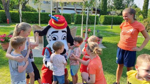 a group of children standing around a horse costume at Park Residence Il Gabbiano in Moniga