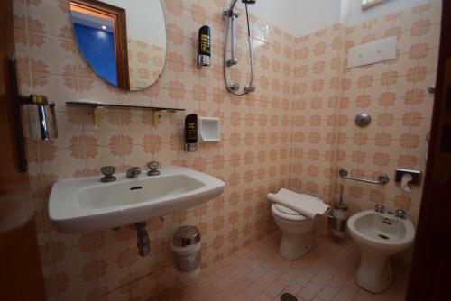 La salle de bains est pourvue d'un lavabo et de toilettes. dans l'établissement Hotel Como, à Rimini