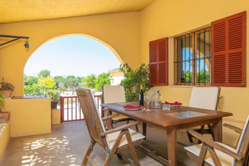 Un comedor con mesa y sillas de madera. en Sa Raconada, en Algaida