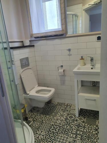 a bathroom with a toilet and a sink at Willa Aura Mare in Dziwnów