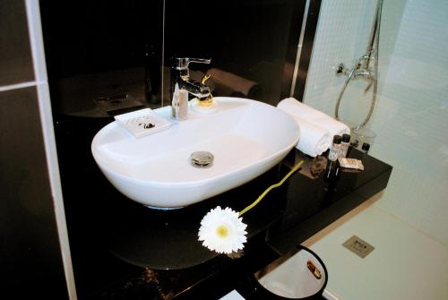 a white sink in a bathroom with a flower at Aveiro, Ria e Fado in Aveiro