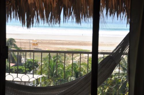 a room with a view of the beach from a hammock at Ananda Guest House Yoga & Meditación in Puerto Escondido