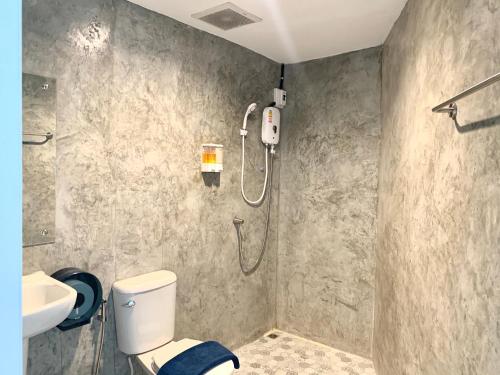 Un baño con ducha, inodoro y lavabo. en Udomsuk Inn & Cafe - BTS Udomsuk, en Bangkok