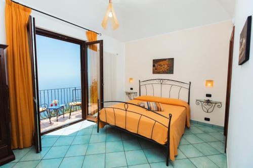a bedroom with a bed and a balcony at Roccia Fiorita in Furore
