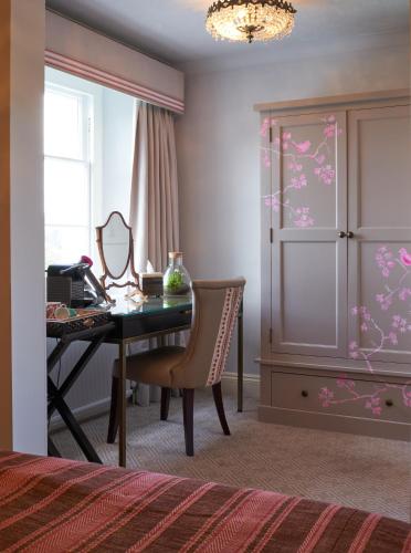 a bedroom with a desk with a mirror and a chair at The Bird, Bath in Bath