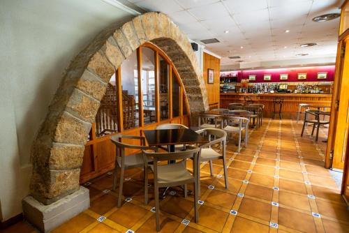 モレラにあるHotel Rey Don Jaimeの石造りのアーチ道とテーブルと椅子のあるレストラン