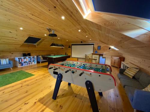 a room with a pool table in the middle of a room at Granary at Kergudon Gîtes, family gîte with pool in Sizun
