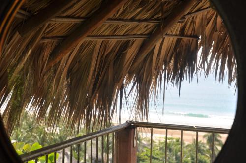 a view of the ocean from a straw hut at Ananda Guest House Yoga & Meditación in Puerto Escondido